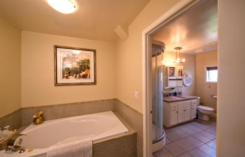 a large bathroom with a tub and a sink at Above the Beach Guest Suites in Penticton