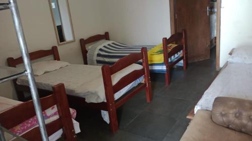 a room with three bunk beds and a table and chairs at Hostel da Moda in Passos