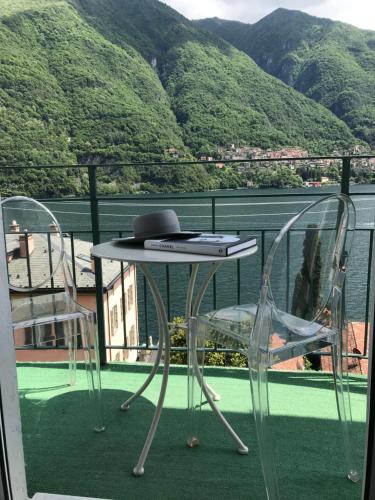 a table and two chairs on a balcony with a view at Hotel Bersagliere in Laglio