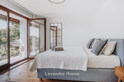 a bedroom with a large bed and a balcony at Lavender House in Osieki
