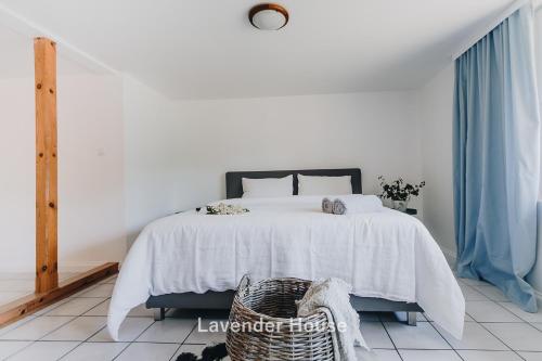 a bedroom with a white bed and blue curtains at Lavender House in Osieki