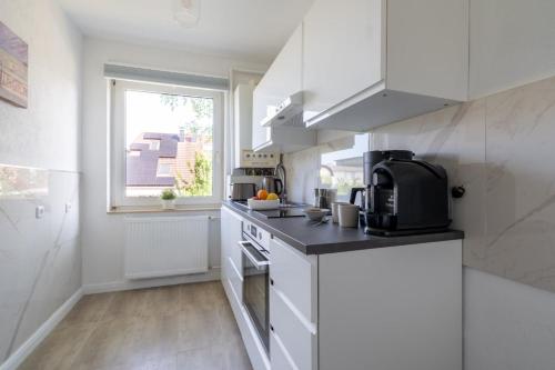 une cuisine avec des appareils électroménagers blancs et une fenêtre dans l'établissement 2-Zimmer-Wohnung in Meeresnähe, à Neustadt in Holstein