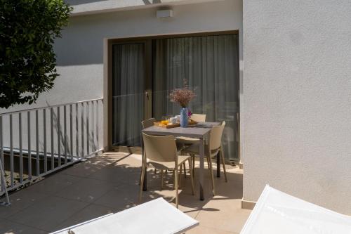 a table and chairs on the balcony of a house at Zlatni Zalaz,Apartments,Supetarska Draga in Supetarska Draga