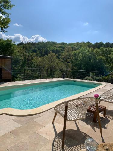een zwembad met 2 stoelen en een tafel bij Private pool-Authentic Perigord Barn-Sarlat 15 min in Calviac