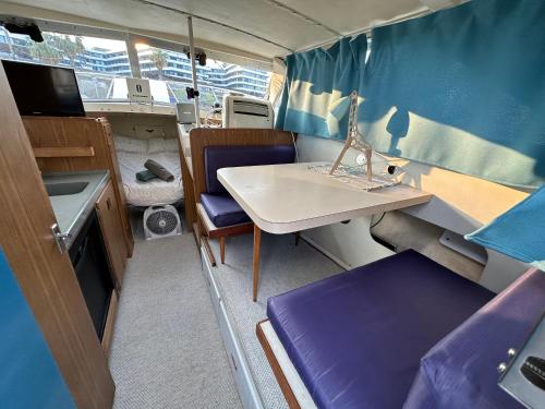 a small room with a desk and a table in a caravan at !!Boat with AC in Port Forum 2 Bikes Included!! in Barcelona