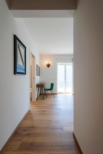 a hallway with white walls and a wooden floor at REVO Apartaments - Gualzi63 the Best View in Sondrio