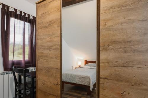 a large wooden mirror in a bedroom with a bed at Apartment Mia in Slunj