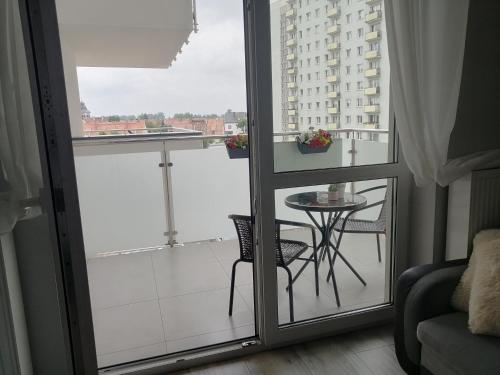 een kamer met een balkon met een tafel en een raam bij Apartament Mielczarskiego in Elblag