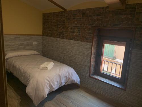 a bedroom with a bed with a mirror and a window at Pensión Valdeverdeja - Entorno Rural y Natural - Castilla La Mancha in Valdeverdeja