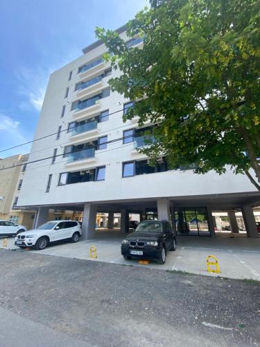 a building with two cars parked in a parking lot at Studio Dear in Eforie Nord