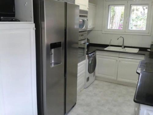 a kitchen with a stainless steel refrigerator and a sink at Chelor in Castelldefels