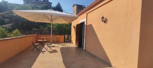 eine Terrasse mit einem Sonnenschirm, einem Tisch und Stühlen in der Unterkunft Petranova Affittacamere B&b in Agropoli