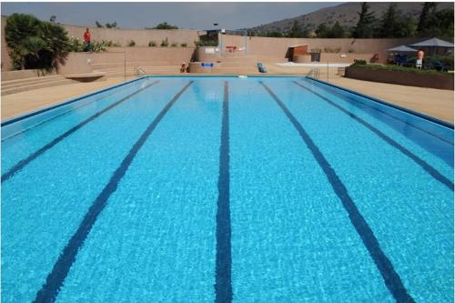 een groot zwembad met blauw water bij מול בנטל in Ein Zivan
