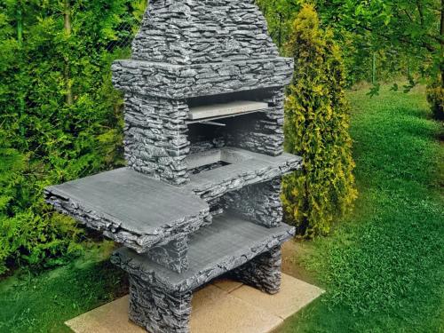 an outdoor stone oven sitting in a garden at Home Apartments 17 in Kołobrzeg