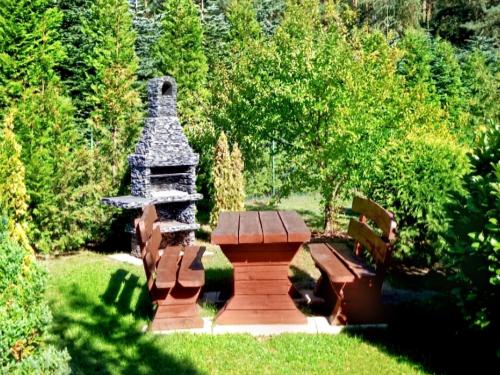 a picnic table and benches in a garden at Home Apartments 17 in Kołobrzeg