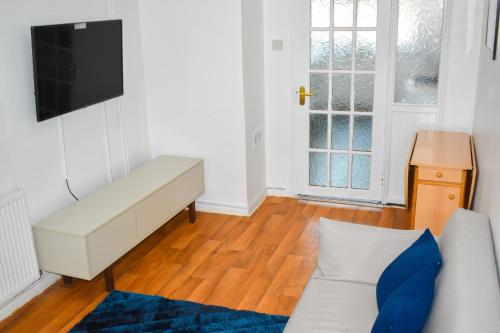 a living room with a couch and a flat screen tv at The Hathway Walk Home in Bristol