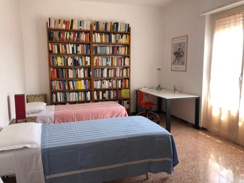um quarto com duas camas e uma estante cheia de livros em Regina em Ortona
