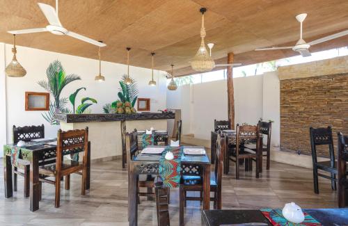 a dining room with tables and chairs and a brick wall at TASNEEM islamic luxury suites in Jambiani