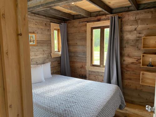 um quarto com uma cama num chalé de madeira em Le Hangar em La Malbaie