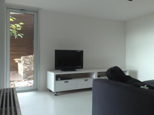 ein Wohnzimmer mit einem Flachbild-TV auf einem weißen Entertainment-Center in der Unterkunft Casa en el Atlantico, Villa encima del Mar, A Guarda, Rias Bajas in A Guarda