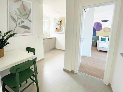 a kitchen and living room with a table and a green chair at Villa Ardura - island holiday residence **** Bol. Island Brač in Bol