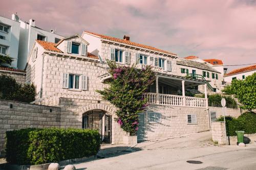 a white brick house with a gate in front of it at Villa Ardura - island holiday residence **** Bol. Island Brač in Bol