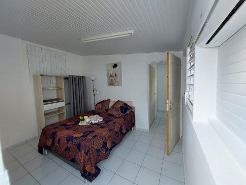 um quarto com uma cama num quarto em Location LUKYNIA em Goyave