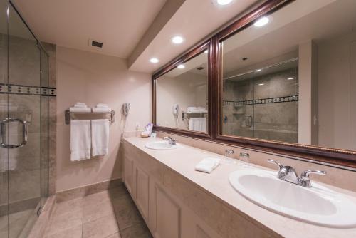 a bathroom with two sinks and a shower at Grand Vista Hotel in Simi Valley