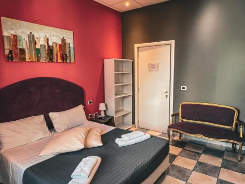 um quarto com uma cama e uma cadeira em Chambres Du Monde em Cagliari