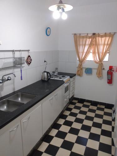 a kitchen with a black and white checkered floor at Villa Coca-Los Agapantos- in Villa la Bolsa
