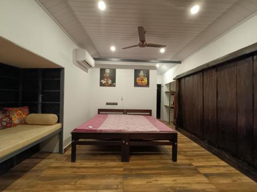 a room with a bed and a table at Anandam Woods - A Heritage single Room for couple-small family in Vaikom