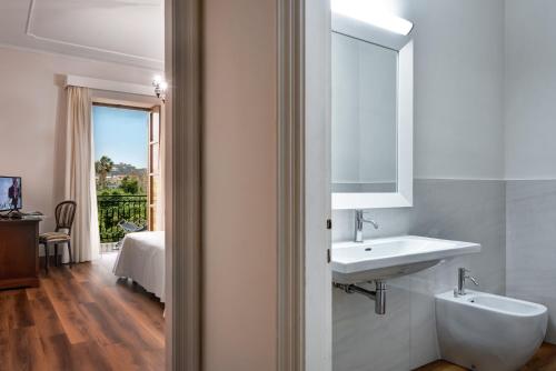 La salle de bains est pourvue d'un lavabo et d'un miroir. dans l'établissement Majestic Palace Hotel, à Sant'Agnello