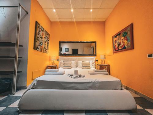 Duas camas num quarto com uma parede laranja em Chambres Du Monde em Cagliari