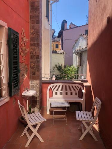 a balcony with chairs and a table and a bench at Il Vicolo in Buti