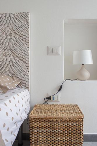 a bedroom with a bed and a table with a lamp at Teia Holiday Apartments in Vulcano