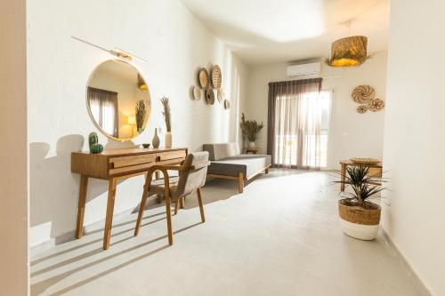 ein Wohnzimmer mit einem Tisch und einem Spiegel in der Unterkunft Dohos Skiathos Suites in Skiathos-Stadt