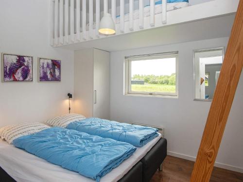 uma cama com lençóis azuis num quarto em Holiday home Haderslev L em Haderslev
