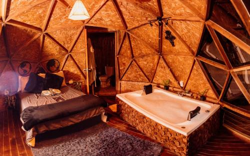 a room with a bed and a tub in a yurt at Glamping Sunset Hill Salamina-Caldas in Aranzazu