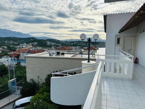 a white balcony with a view of a city at Cost Mari Almyrida New by ZAGO Boutiqe hotels in Almirida