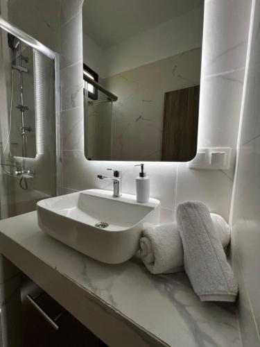 a white bathroom with a sink and a mirror at Naiades Villas Aigli in Ladharió