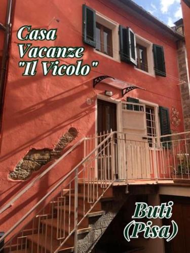 a red building with a sign for a restaurant at Il Vicolo in Buti