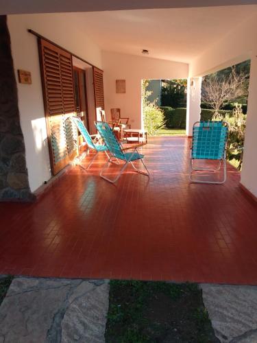 a patio with blue chairs and a table at Villa Coca -Los Jilgueros- in Villa la Bolsa