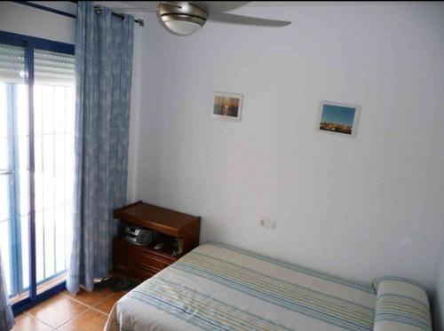 Un dormitorio con una cama y un televisor y una ventana. en Dúplex casa agua, en San José