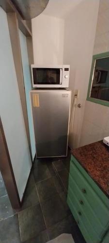 uma cozinha com um micro-ondas em cima de um frigorífico em Moderno y acogedor departamento céntrico em Posadas