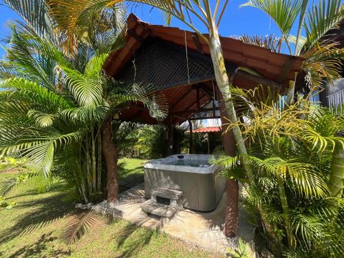 una bañera de hidromasaje fuera de un complejo con palmeras en Pitangus Lodge, en Chachagua