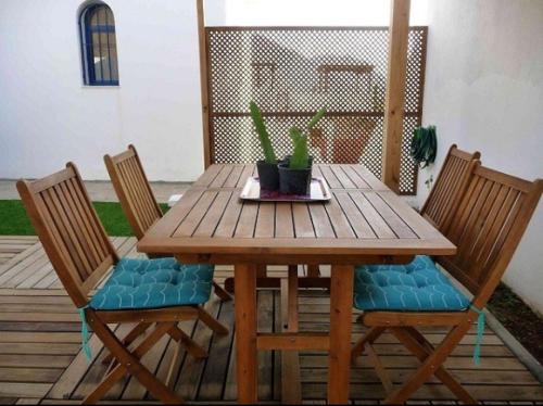 una mesa de madera con 2 sillas y una mesa con plantas en Dúplex casa agua, en San José