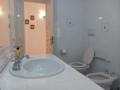 a white bathroom with a sink and a toilet at Villetta Panoramica in Ischia