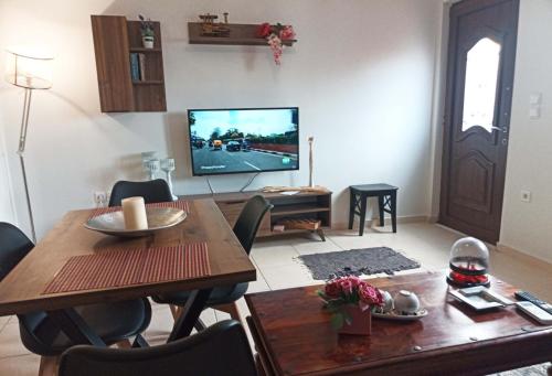 a living room with a table and a tv at Vaikouzis Houses in Samothráki
