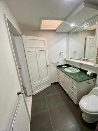 a bathroom with a sink and a toilet and a mirror at San Laurent in Cali