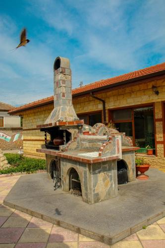 a stone oven in front of a house at Albena Guest House in Shabla